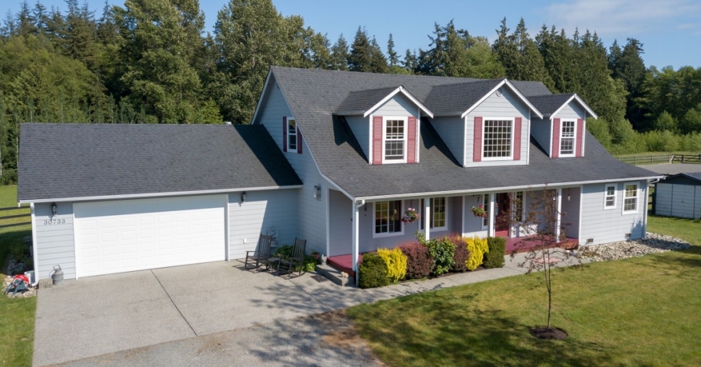 A house with a clean yard and mid-sized garage.